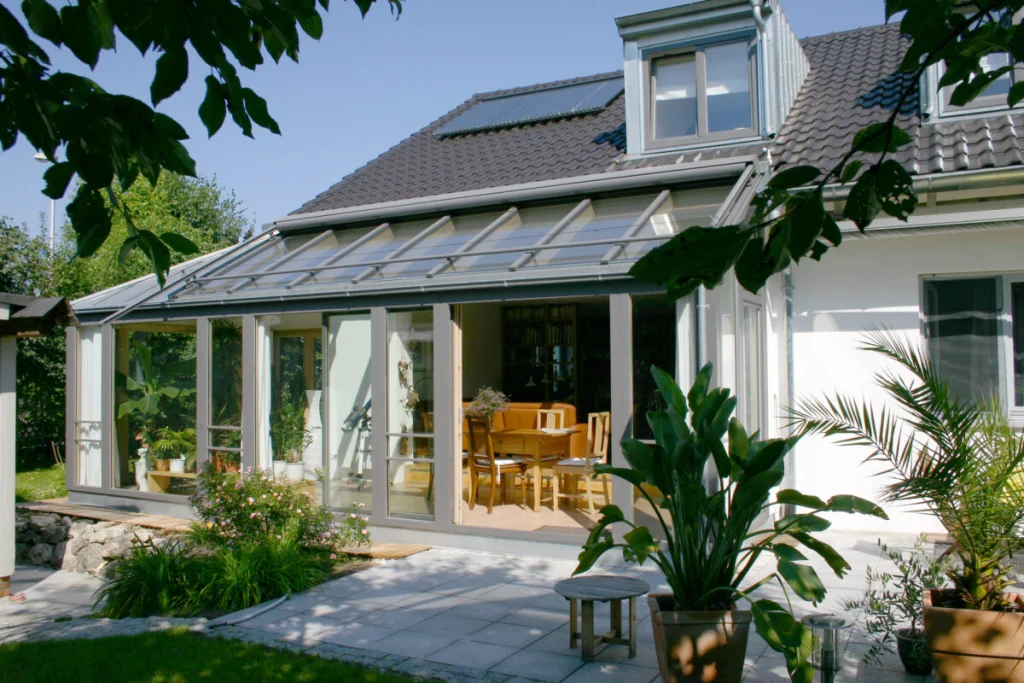 Wintergarten in Großenseebach mit Pultdach und grauer Holz-Alu-Konstruktion, Blick von der Terrasse