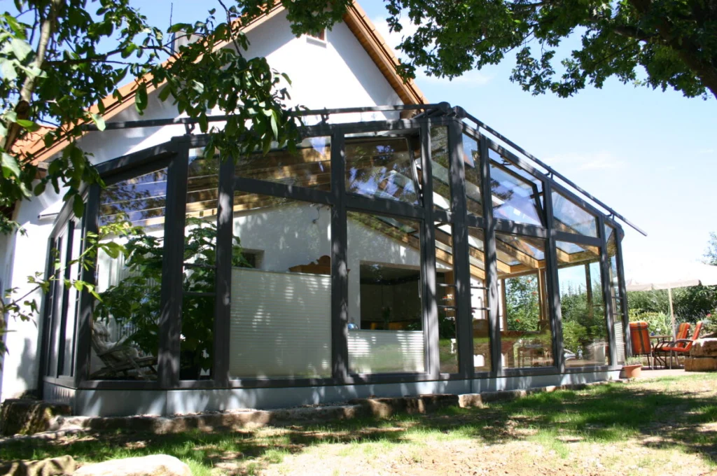 Wintergarten in Kunreuth mit Satteldach, außen anthrazit, innen Holz natur, Blick über den Garten