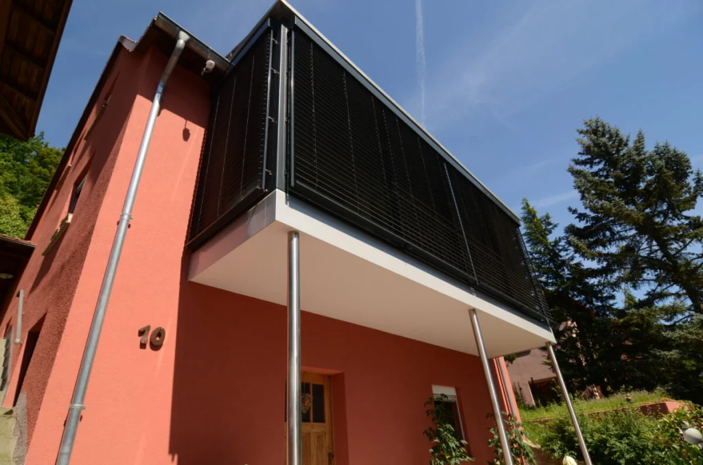 Anbau im Obergeschoss in Marktsteinach, Raffstore vor der Verglasung, Balkon auf Edelstahlstützen am roten Haus
