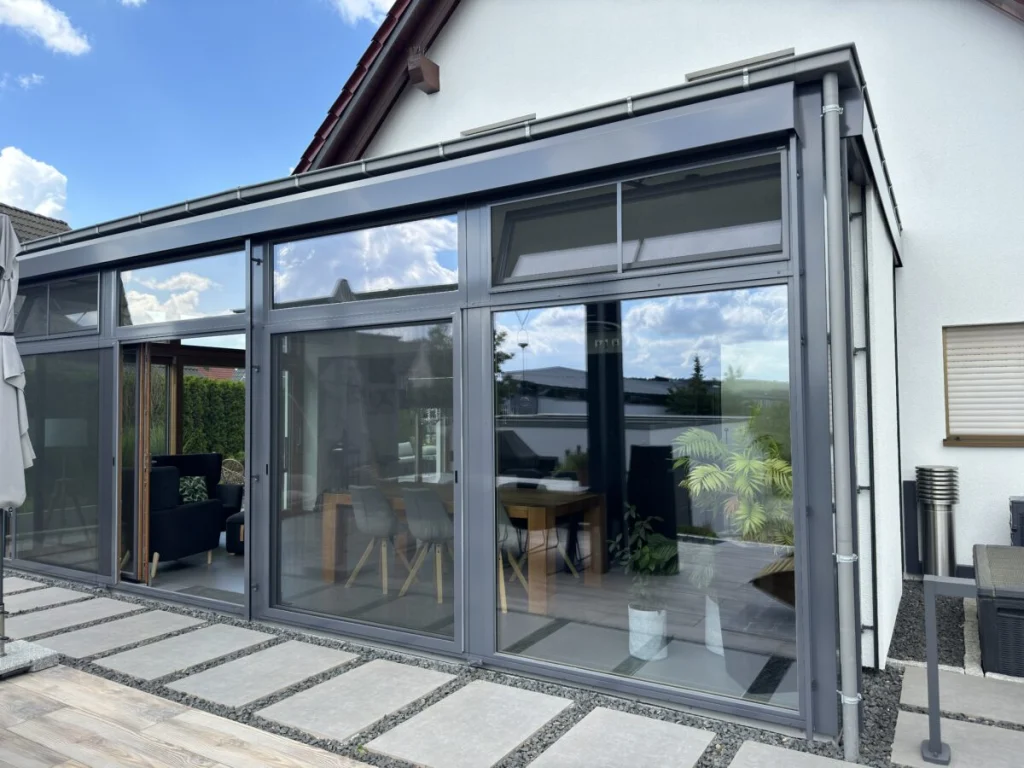 Anbau in Benzendorf mit anthrazitfarbenen Rahmen, geöffnetem Kippfenster und gedämmter Wand am Haus