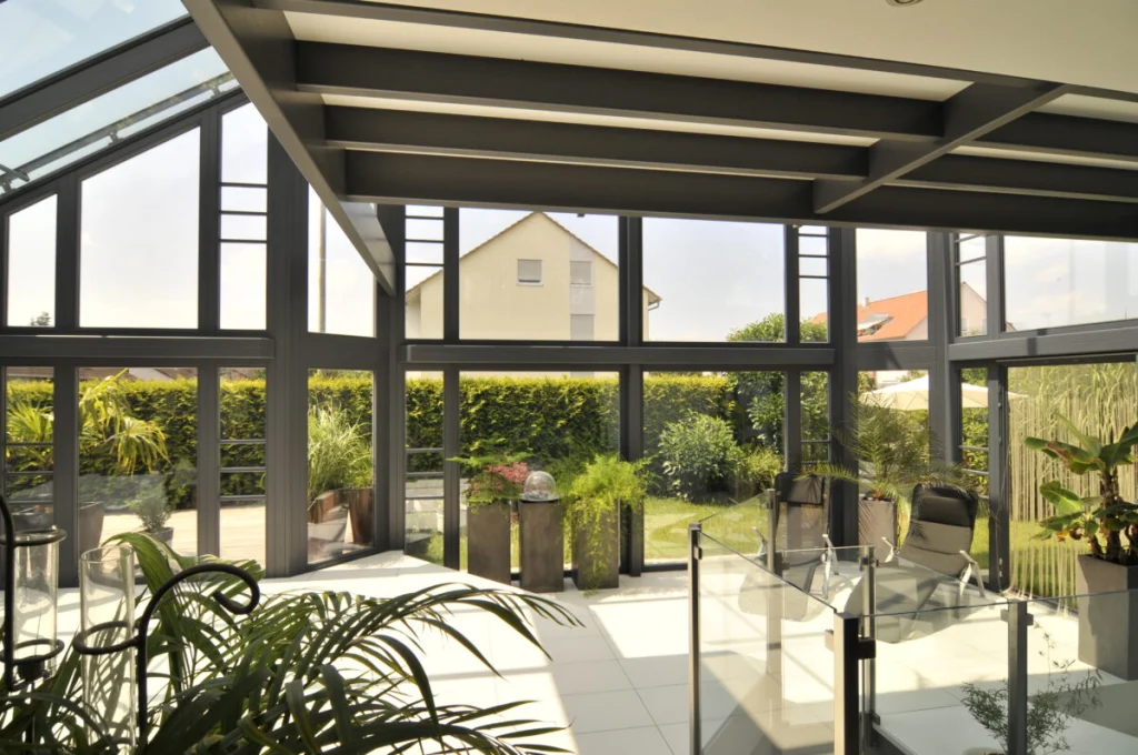 Wintergarten in Baiersdorf über zwei Geschosse, Innenansicht mit dunkelgrauer Konstruktion und Blick in den Garten