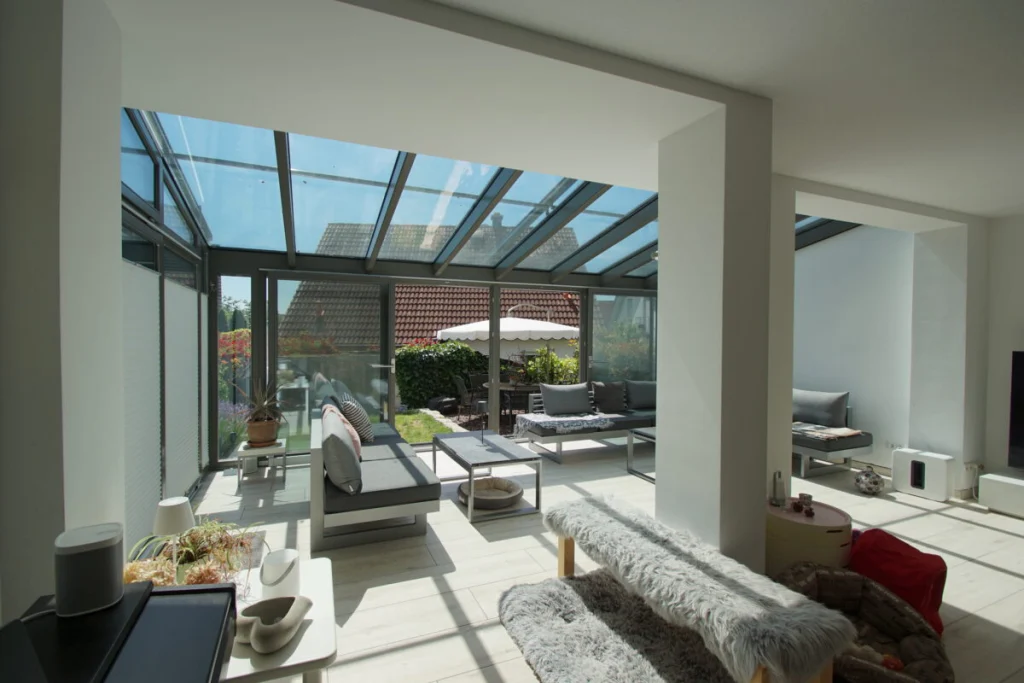 Wintergarten in Baunach vom Wohnzimmer aus, Glasdach mit grauen Profilen und Blick auf Terrasse und Garten