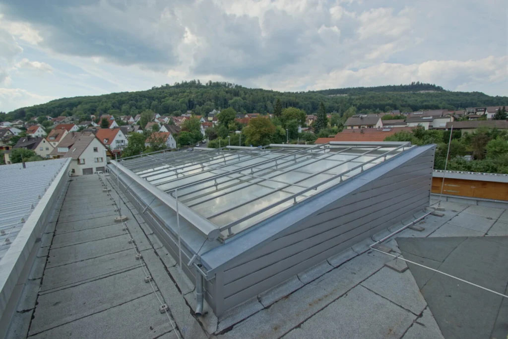 Glasdach der Klinik Ebermannstadt von oben, grau verkleideter Dachaufbau auf dem Flachdach, Blick über den Ort