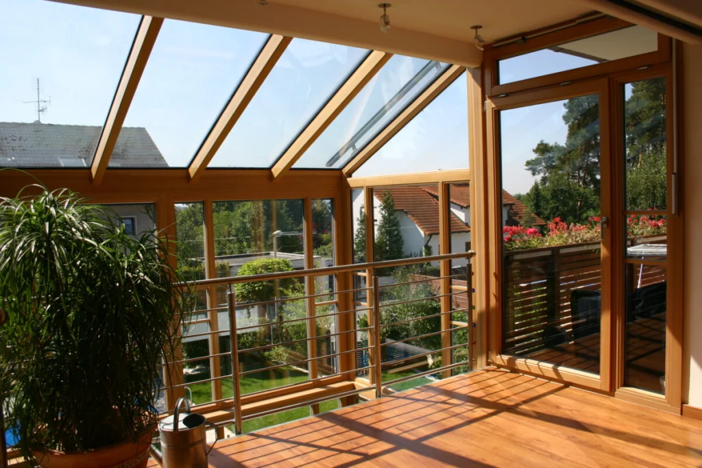 Obergeschoss des Wintergartens in Bubenreuth mit Glasdach, Holzboden, Balkongeländer innen und Tür zum Balkon