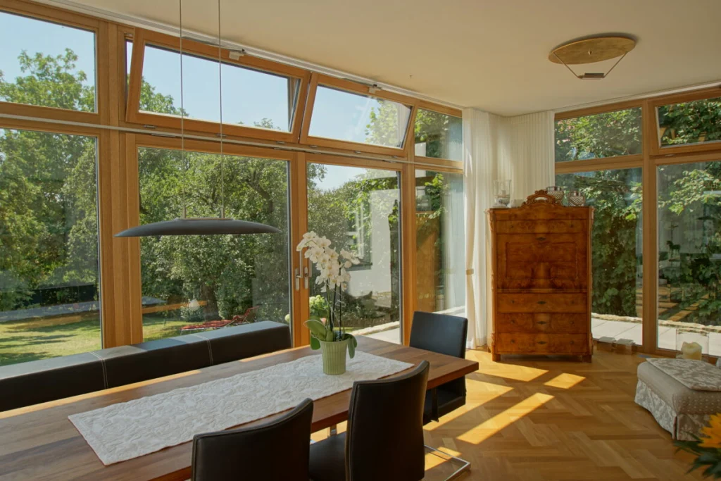 Esszimmer-Anbau in Coburg von innen mit bodentiefer Verglasung, Holzrahmen natur und Blick in den Garten