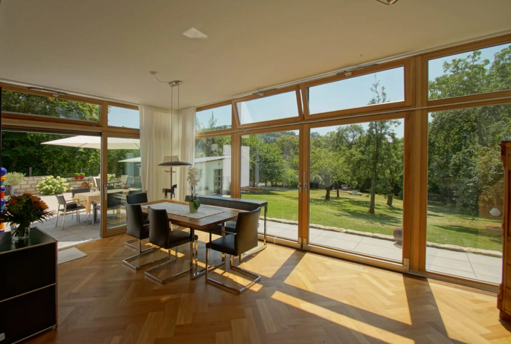 Esszimmer-Anbau in Coburg mit geöffneter Schiebetür zur Terrasse, Holzrahmen und Parkett