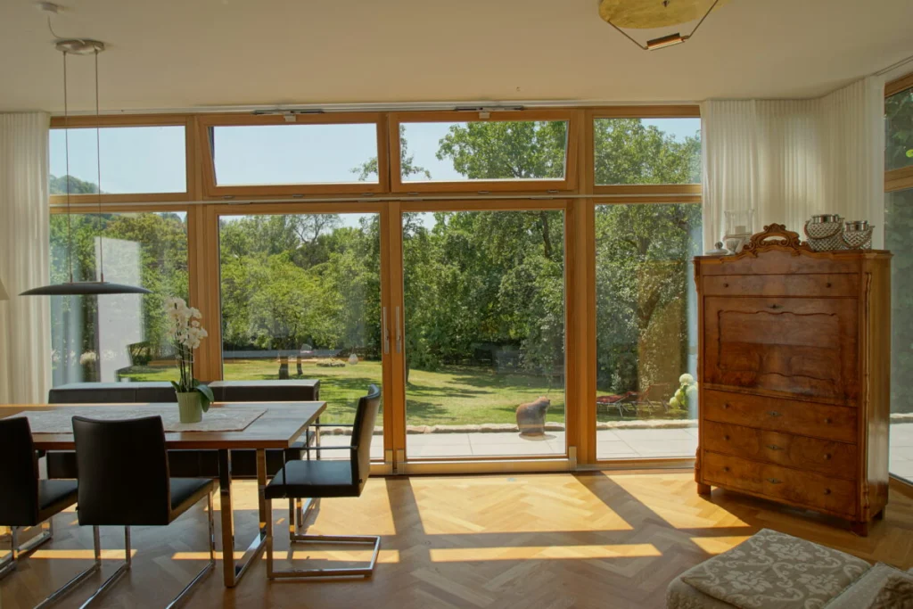Bodentiefe Glasfront mit zweiflügeliger Schiebetür im Anbau in Coburg, Blick auf Terrasse und Garten