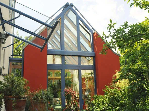 Glasanbau mit rotem Giebel und Glasdach am Wohnhaus