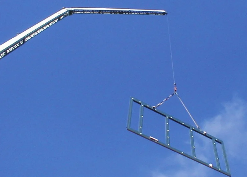 Kranausleger mit Hebetraverse vor blauem Himmel