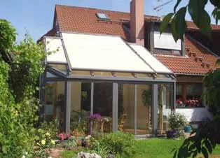 Wintergarten mit rot-weißer Dachmarkise und Terrasse