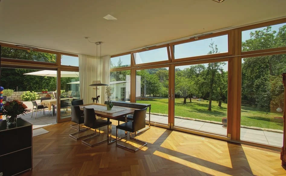 Großes Esszimmer im Anbau mit Holzrahmen und Blick in den Garten